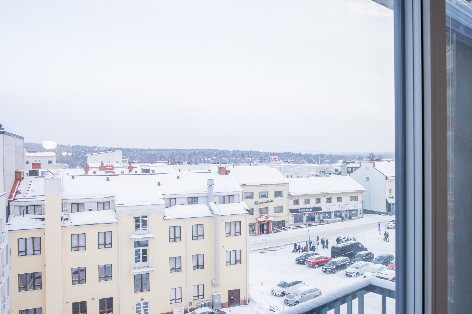 Blick über die verschneiten Dächer der Innenstadt von Rovaniemi vom Suite Apartment