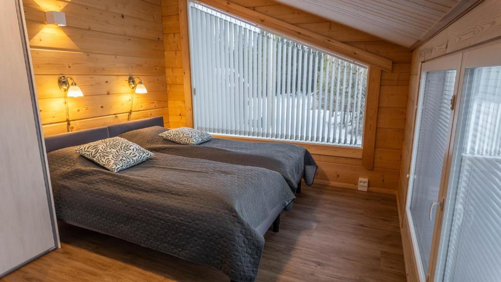 Bedroom with two single beds and a window onto the forest